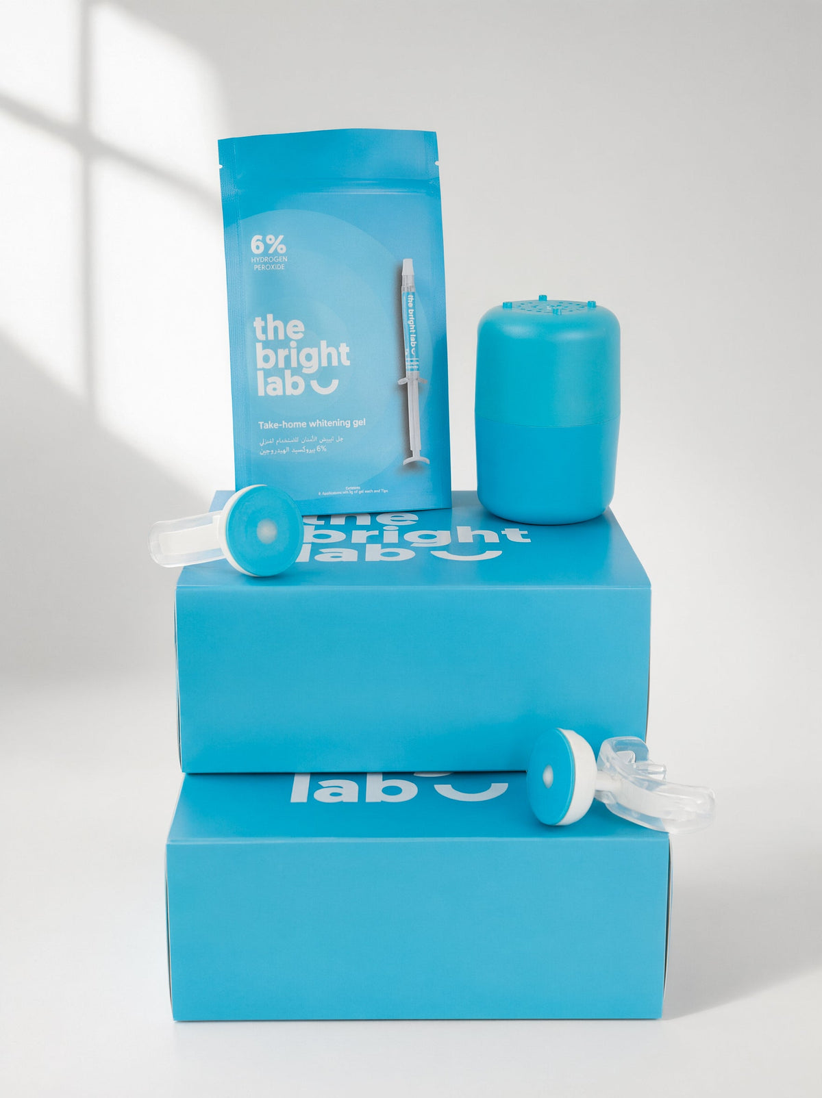 The whitening gel refill sachet standing against the Bright Lab boxes with the case and mouthpiece