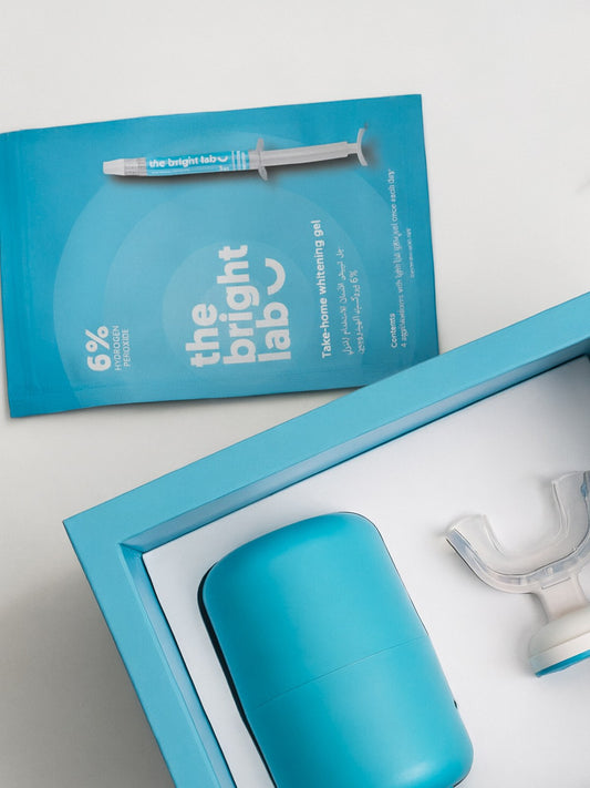 The Bright Lab 6% take-home whitening gel refill sachet with a 3g gel applicator, resting beside the Whitening System case