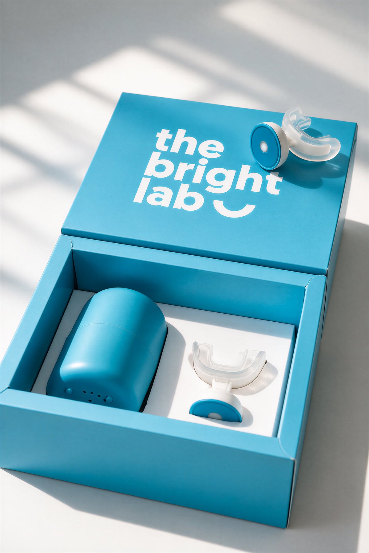 The Bright Lab presentation box opened, showing the teal case and LED mouthpiece in the tray
