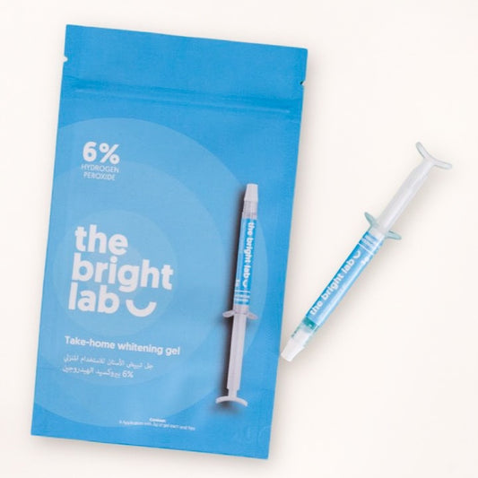 The Bright Lab 6% hydrogen peroxide take-home whitening gel pouch beside a 3g gel syringe
